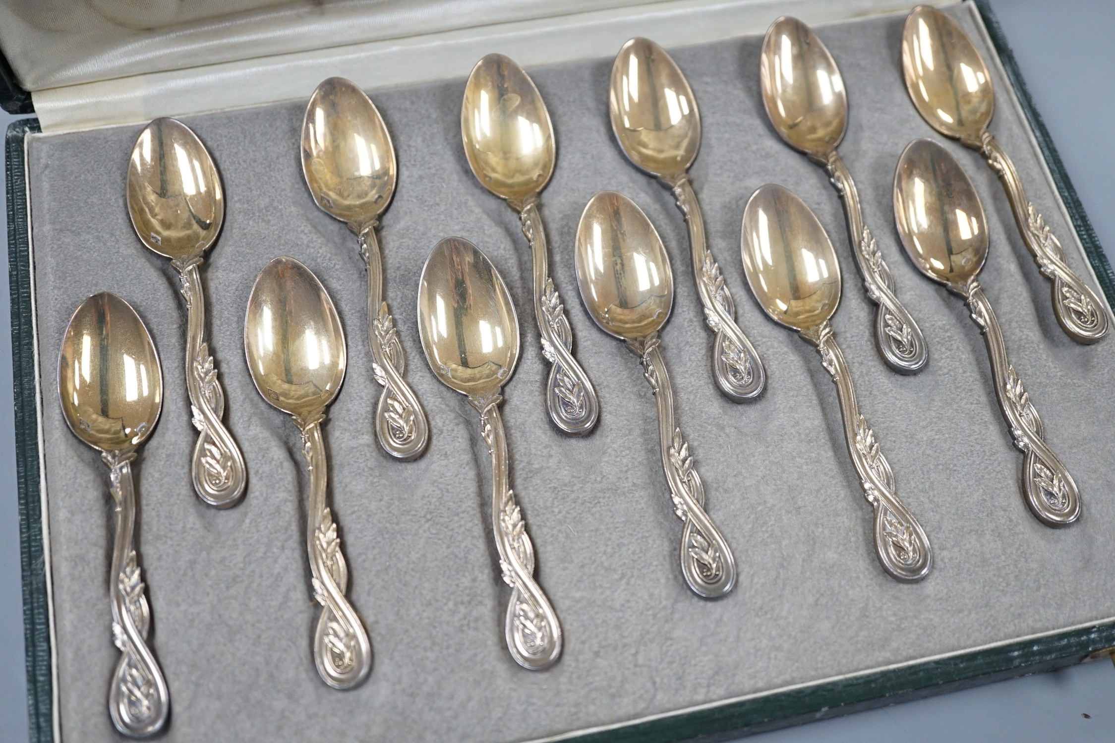 A cased set of twelve early 20th century French 950 standard white metal teaspoons, with foliate scroll terminals, by H. Freres & Co, 99mm.